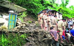 Rescuers search for people among the debris of houses after a landslide in Chamoli district on Wednesday.  PTI