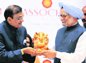 Assocham chief Rajkumar Dhoot presents an idol of Lord Ganesha to PM Manmohan Singh In New Delhi. 