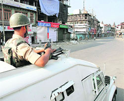 A security man keeps vigil during curfew in Srinagar.