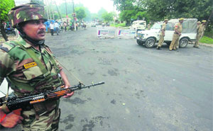 A soldier stands guard during a curfew in the Muthi area on the Jammu-Poonch highway. 