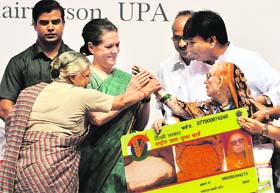 AICC chief Sonia Gandhi and Delhi CM Sheila Dikshit present the national food security card to a woman in New Delhi