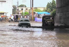 Vehicles cross a waterlogged underpass near Jugiana village