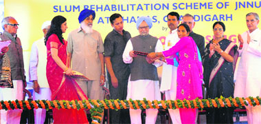 PM Manmohan Singh hands over the papers of a flat to a beneficiary at Dhanas village in Chandigarh on Saturday. Also seen are Haryana CM BS Hooda (extreme left), his Punjab counterpart PS Badal (3rd from left), Punjab Governor Shivraj Patil (3rd from right),  Housing and Urban Poverty Alleviation Minister Girija Vyas (2nd from right) and local MP Pawan Kumar Bansal (extreme right). 