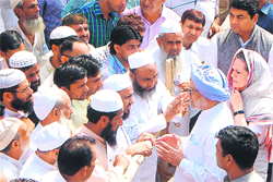 PM Manmohan Singh and Congress president Sonia Gandhi meet villagers during a visit to Muzaffarnagar on Monday.  AFP