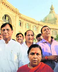 BJP leader Uma Bharti protests with party MLAs against whom arrest warrants were issued, at the Vidhan Sabha in Lucknow on Wednesday