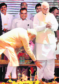 BJPs PM nominee Narendra Modi seeks blessings of  LK Advani at a rally in Bhopal on Wednesday. 