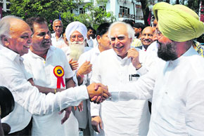 Union Minister Kapil Sibal looks on PPCC chief Partap Singh Bajwa shakes hands with former state finance minister Surinder Singla at Bathinda on Wednesday.