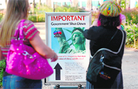 Tourists look at a sign announcing closure of the Statue of Liberty, in New York on Tuesday. 
