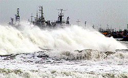 Big waves smash into a breakwater at a fishing harbour in Visakhapatnam, Andhra Pradesh, on Friday