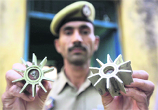 A policeman shows tailfins of 82mm mortars fired by Pakistan Rangers in Rangpur village of the Pargwal sector. 