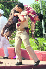 An injured being carried by a police personnel to a hospital after the blasts in Patna on Sunday.