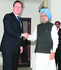 British PM David Cameron shakes hands with Manmohan Singh in New Delhi on Thursday