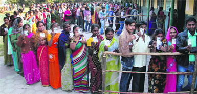 Voters line up at a polling station in Shalimar Bagh, Delhi. PTI