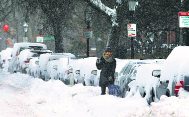 A man clears snow near his car after a blizzard in Boston. 
