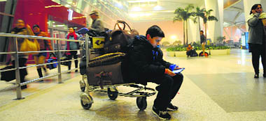 A boy waits for his fog-affected flight at IGI Airport in New Delhi on Monday.
