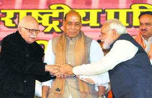 BJP PM candidate Narendra Modi greets LK Advani during the party's national council meeting in New Delhi on Sunday. BJP chief Rajnath Singh is also seen. 