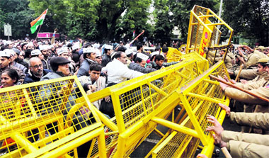 AAP supporters try to break a barricade during a protest in New Delhi.