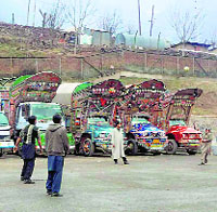 Stranded Pakistani drivers play volleyball in front of their trucks after they were stopped by authorities at Salamabad Trade Center in Uri on Tuesday
