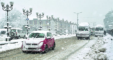 Motorists brave fresh snowfall in Srinagar on Wednesday. Several parts of the Kashmir Valley experienced heavy snowfall leading to the closure of the Jammu-Srinagar national highway. Photo: Yawar Kabli