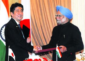 Prime Minister Manmohan Singh shakes hands with his Japanese counterpart Shinzo Abe after signing a joint agreement in New Delhi on Saturday