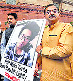 BJPs Tarun Vijay and Anurag Thakur hold Nido Taniams poster in New Delhi