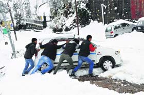 Frozen wheels: A car stuck in snow in Naddi, Dharamsala, on Saturday
