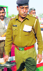 A police officer holds a shoe hurled at Hooda during the rally.
