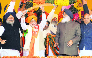 BJP's PM nominee Narendra Modi is flanked by SAD chief Sukhbir Singh Badal (L) and Punjab CM Parkash Singh Badal at a rally in Jagraon. BJP chief Rajnath Singh is on extreme right.