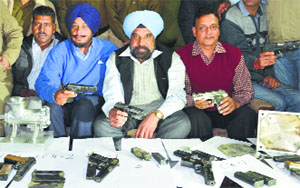 Customs officials show the weapons recovered from Samjhauta Express passengers at Attari railway station on Thursday. 