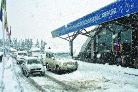Passengers wait in their vehicles outside Srinagar airport on Tuesday