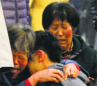 Relatives of passengers aboard Malaysia Airlines flight MH370 console each other in Beijing on Monday. AFP