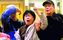 A relative of a Chinese passenger aboard Malaysia Airlines flight MH370 grieves in Beijing