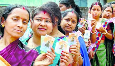Women pose with their voter IDs before casting their ballot at a polling station at Dibrugarh in Assam on Monday.