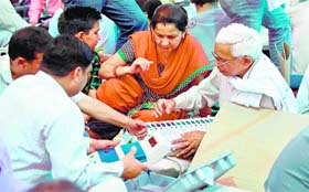 Officials check EVMs at a distribution centre in Ghaziabad on Wednesday