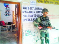 Udhampur votes today: A security man stands guard at a polling booth in Udhampur.