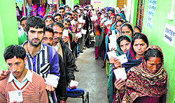 Voters wait for their turn at a polling booth in Ramban in Jammu region