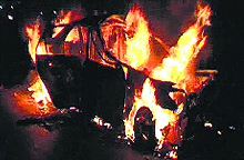 The car that caught fire after an accident near Kurar village on NH-1 in Sonepat district