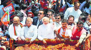 BJP prime ministerial candidate Narendra Modi waves to his supporters during a road show before filing his nomination papers in Varanasi on Thursday.