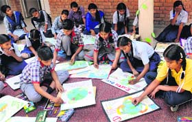 Students of Tribune Model School take part in a poster-making competition on Friday