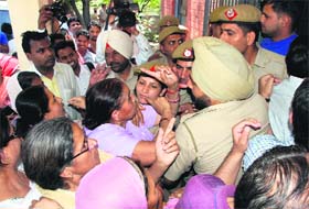 Policemen trying to stop women from entering the police post, Sector 19, Panchkula