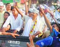 AAP convener Arvind Kejriwal waves to his supporters during a roadshow in Varanasi on Friday