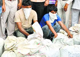 The suspects and seized poppy husk in police custody in Ludhiana on Monday