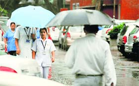 Residents take out umbrellas to fend off rain