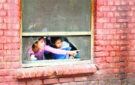 Students watch the fire at Government Primary School, Jawahar Nagar Camp, in Ludhiana on Monday