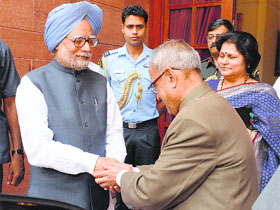 President Pranab Mukherjee (R) greets outgoing PM Manmohan Singh at the Presidential Palace in New Delhi on Saturday.