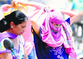 A girl covers her face to protect herself from the scorching heat in Ludhiana on Wednesday