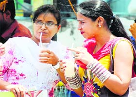 No respite from heat: Girls enjoy a cool drink to quench their thirst