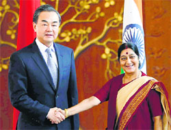 Chinese Foreign Minister Wang Yi (L) shakes hands with Sushma Swaraj before their meeting in New Delhi on Sunday.