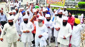 Sarpanch Sukhdev Singh and his supporters raise slogans outside the Police Commissioner’s office in Ludhiana on Wednesday