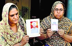 Mothers of two Punjab youths trapped in Mosul (Iraq) hold their sons photos in Amritsar